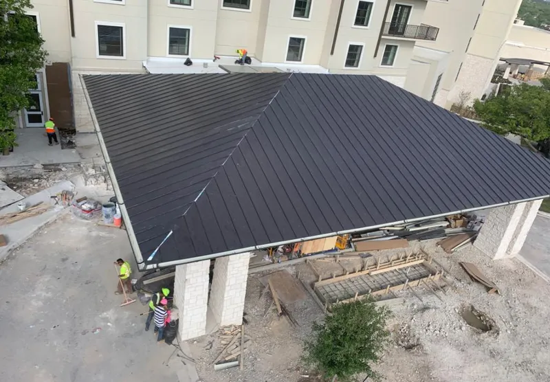 Metal roofing installation team working on a commercial building in River Road